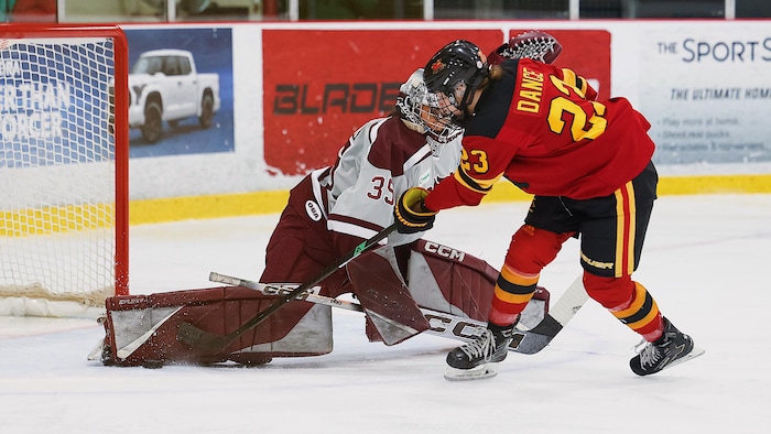 Une gardienne de but fait un arrêt spectaculaire en étirant la jambière lors d'un match universitaire.