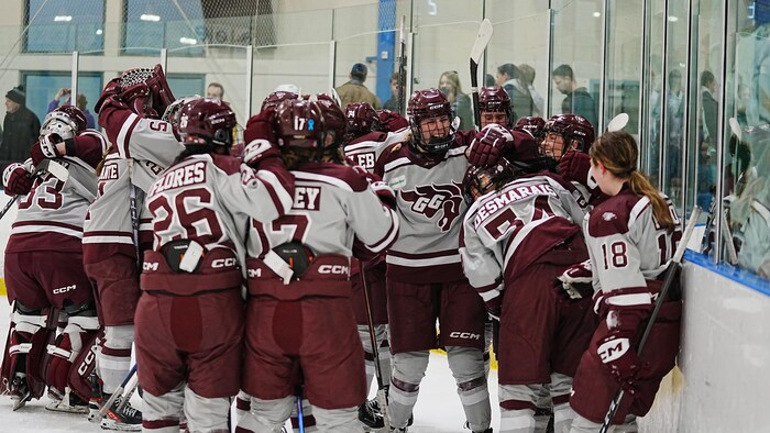 Des joueuses de hockey célèbrent une victoire sur la glace. 
