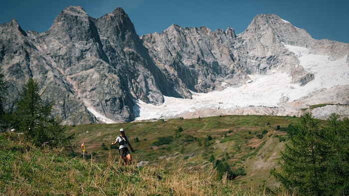 Une femme court dans les montagnes.