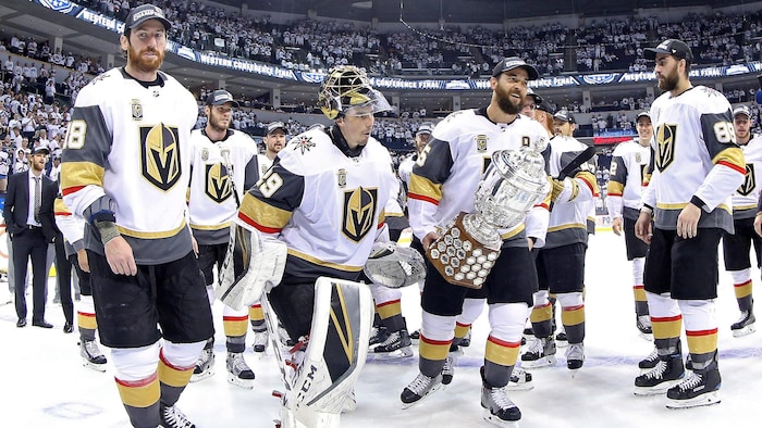 Des joueurs des Golden Knights tiennent un trophée.