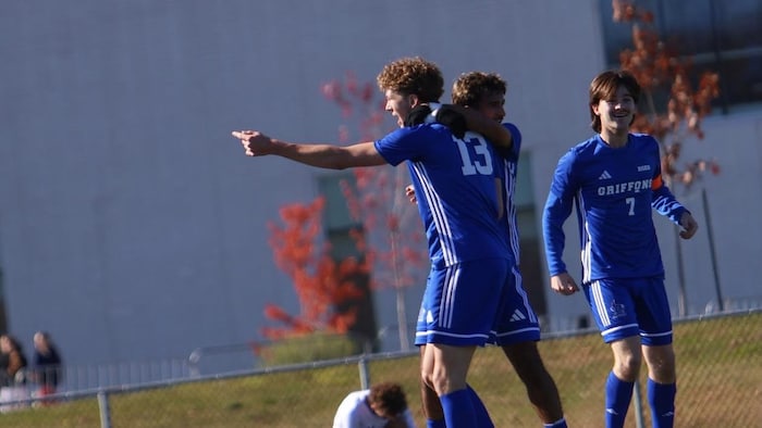 Des joueurs de soccer collégial célèbrent un but. 