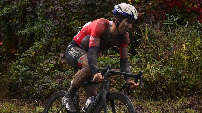 Un cycliste pédale dans la boue.