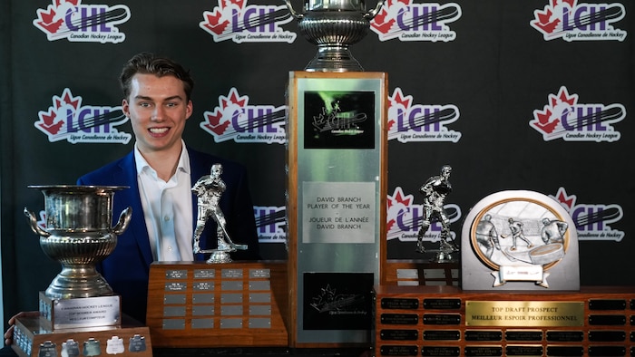Il pose avec ses trois trophées.