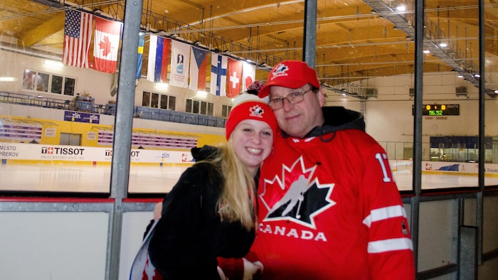 La hockeyeuse enlace son père aux abords de la glace.