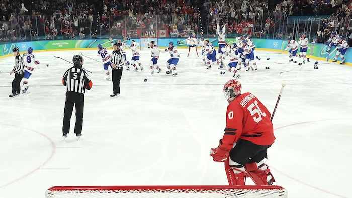 Des hockeyeurs sautent sur la glace après le but victorieux en prolongation.