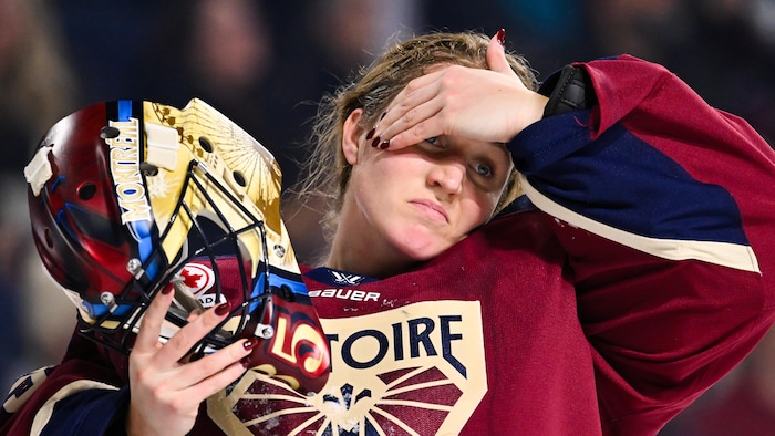 La gardienne de but de la Victoire de Montréal retire son masque et se passe la main au visage.