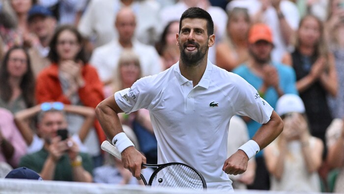 Un joueur de tennis célèbre sa victoire.        