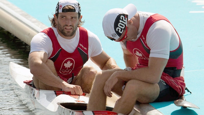 Des athlètes reprennent leur souffle après une course de kayak. 