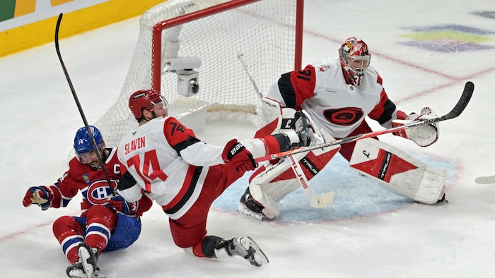 Nick Suzuki tombe sur la glace, devant le gardien des Hurricanes.