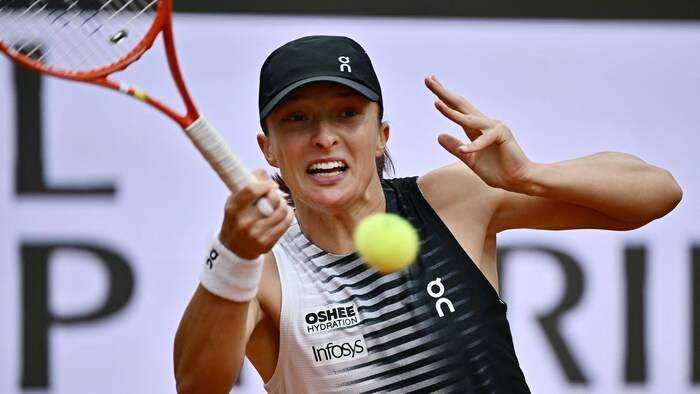 Elle grimace au moment de frapper une balle de tennis.