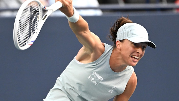 Une joueuse de tennis fait un service. 