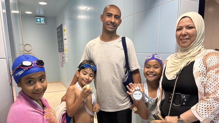 Une famille avec trois enfants à la piscine