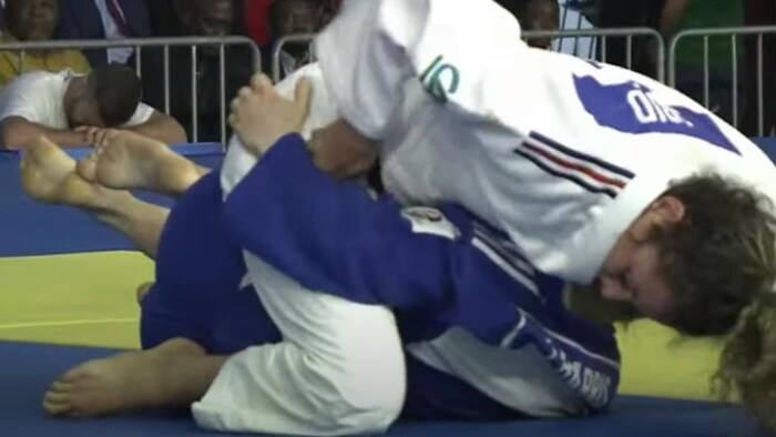 Deux judokas sont sur le tatami, l'entraîneur a la tête dans les mains.