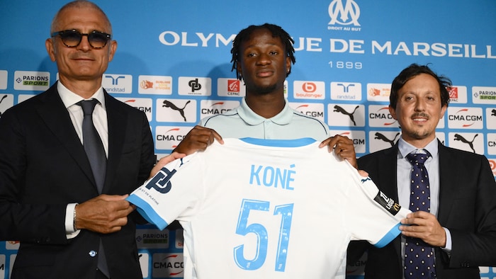Ils tiennent un maillot avec le nom du joueur et le numéro 51.