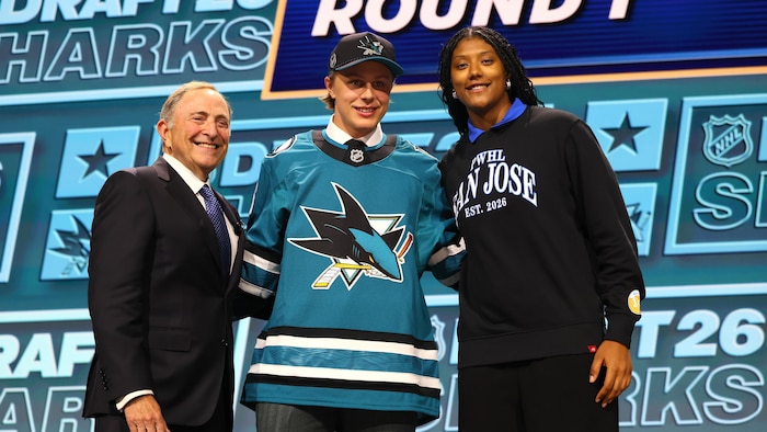 Il pose pour une photo avec le chandail des Sharks, aux côtés du commissaire Gary Bettman.