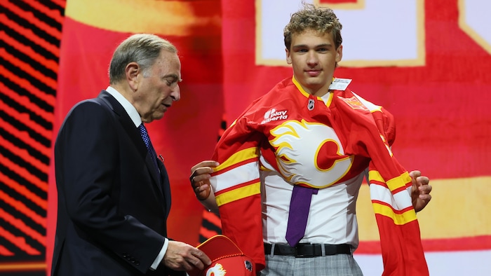 Il enfile le chandail des Flames.