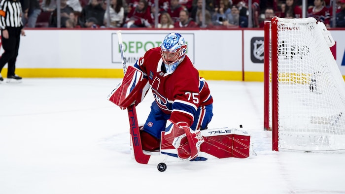 Un gardien de but au hockey effectue un arrêt.