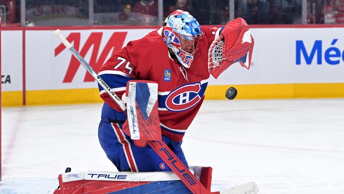 Un gardien de hockey arrête une rondelle.