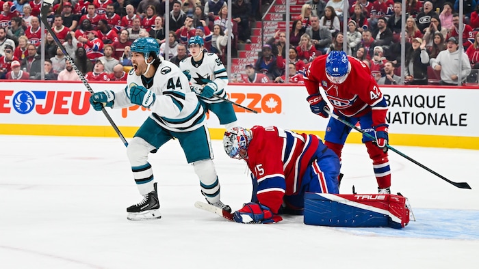 Un gardien l'air abattu sur la glace après un but de l'adversaire.