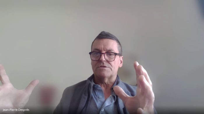 Un homme bouge ses mains en parlant.