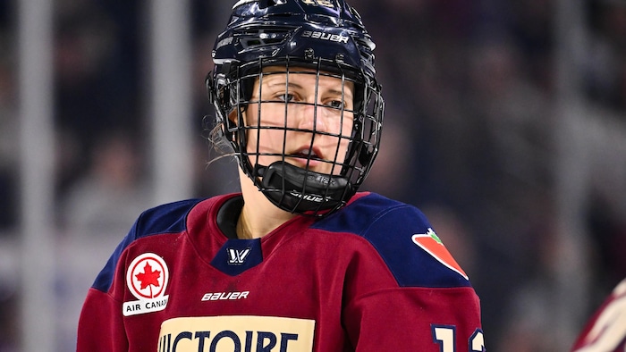 Une joueuse de hockey regarde au loin.