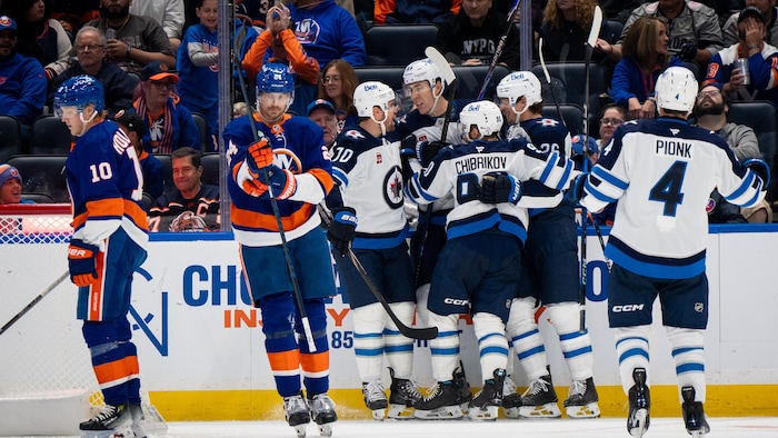 Des joueurs de hockey se réjouissent à proximité de deux adversaires.