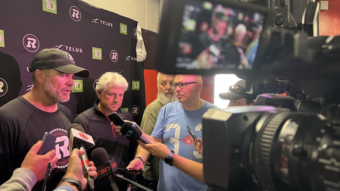 Deux dirigeants d'une équipe de football professionnel rencontrent les médias.