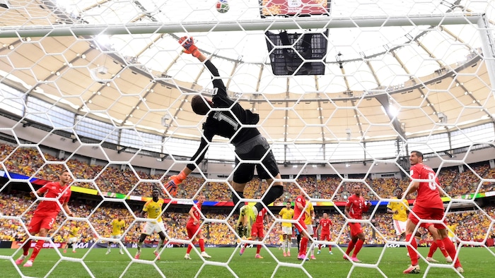 Des joueurs voient le ballon se faire repousser par la transversale.