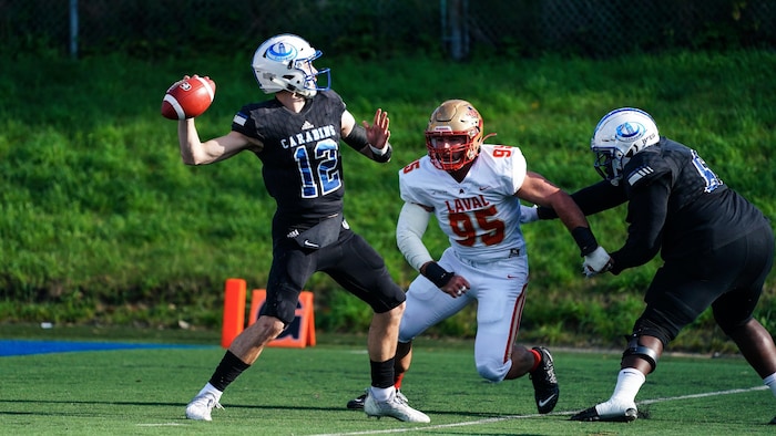 Un footballeur s'apprête à lancer une passe avant d'être frappé.