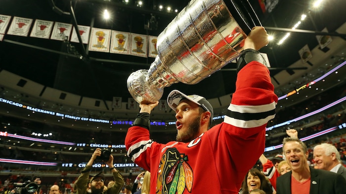 Jonathan Toews soulève la coupe Stanley après la victoire des Blackhawks de Chicago sur le Lightning de Tampa Bay, au sixième match de la finale en juin 2015.