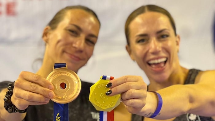 Deux femmes montrent leur médaille d'or.