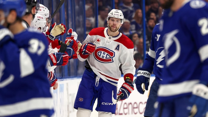 Un joueur de hockey célèbre au banc avec ses coéquipiers.
