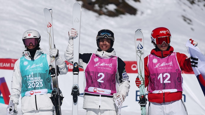 Les skieurs sourient sur le podium.