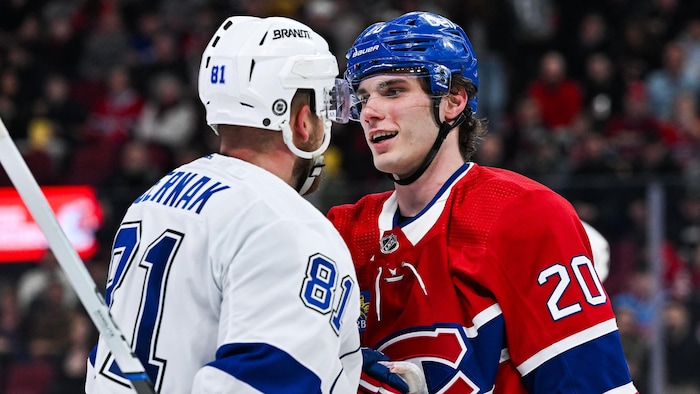 Deux hockeyeurs sont l'un devant l'autre.