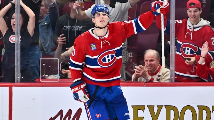 Un joueur de hockey célèbre son but en levant son bras.