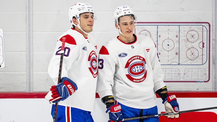 Deux joueurs discutent le long de la bande.