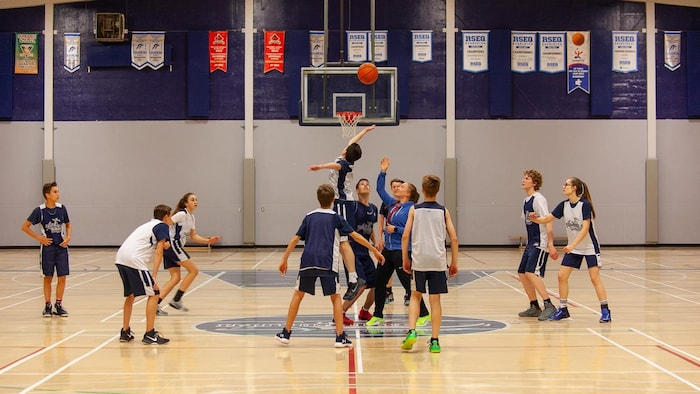 Une dizaine d'adolescents jouent au basketball.