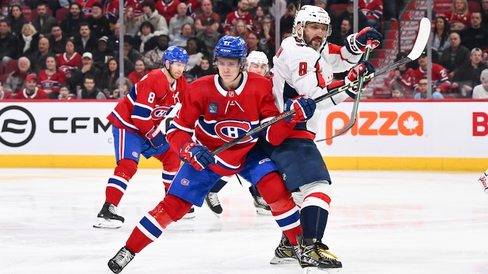 Un hockeyeur bloque un adversaire.