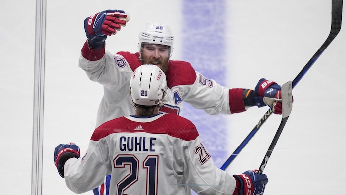 Les deux joueurs célèbrent un but ensemble.