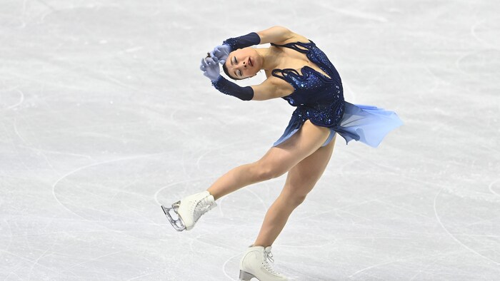 Une patineuse artistique effectue une pirouette cambrée.