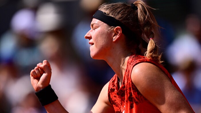 Une joueuse de tennis brandit le poing pour exprimer sa satisfaction pendant un match.