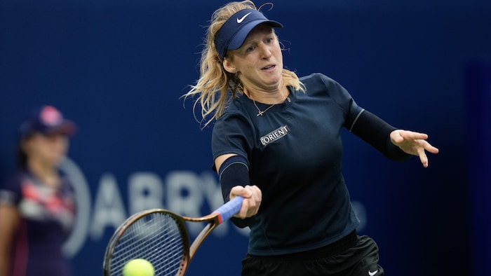 Une joueuse de tennis frappe un coup droit.