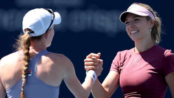 Deux joueuses de tennis se serrent la main.