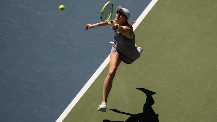La joueuse de tennis Kayla Cross s’étire pour atteindre une balle.