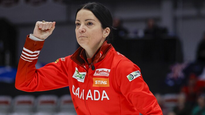 Une joueuse de curling serre le poing.