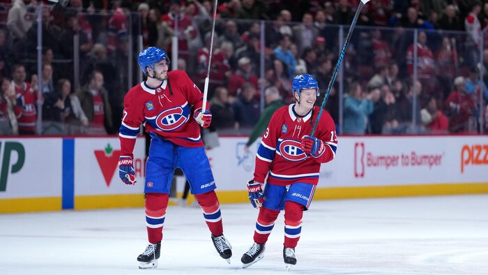 Kirby Dach et Cole Caufield célèbrent la victoire du Canadien face au Wild.