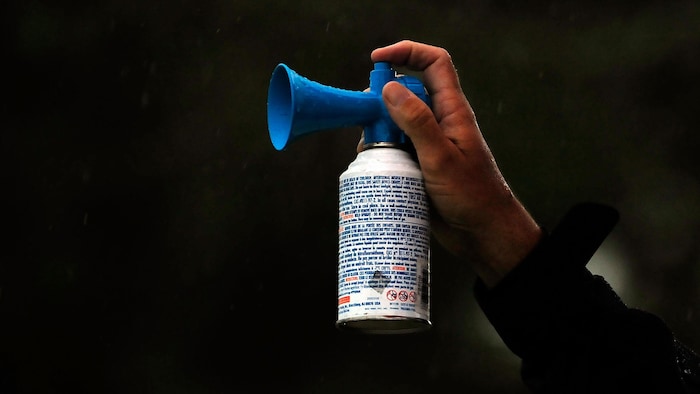 Un partisan tient une cannette sur laquelle se trouve un embout en forme de corne.