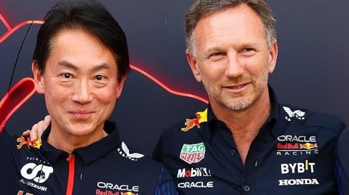 Two men, side by side, smile for the photo wearing sponsored corporate shirts.