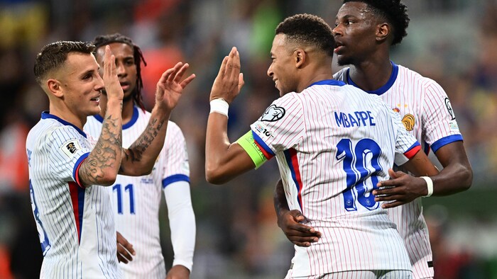 Quatre joueurs de soccer célèbrent un but.