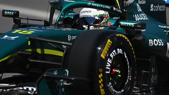 Lance Stroll au volant de son Aston Martin verte et jaune. 